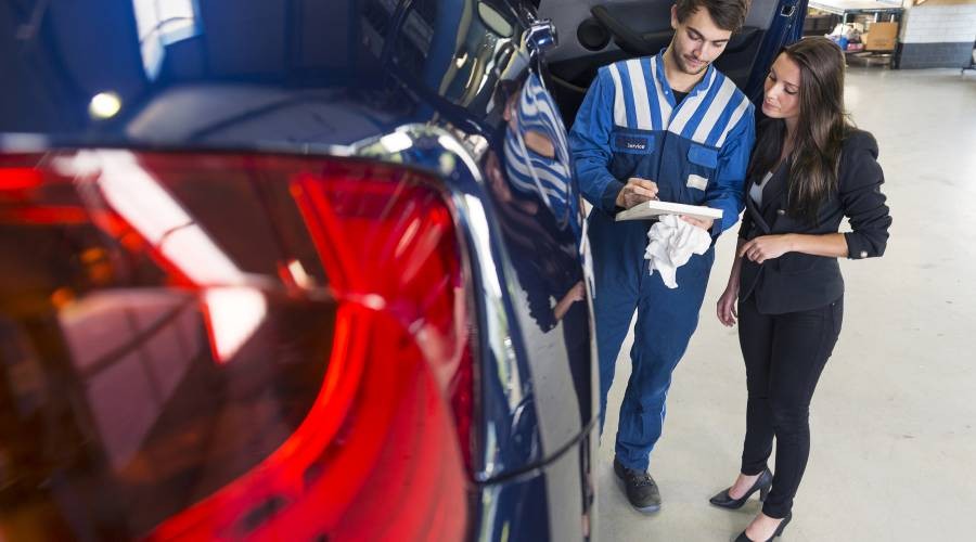 De klant haar auto is gemaakt Klant met de automonteur
